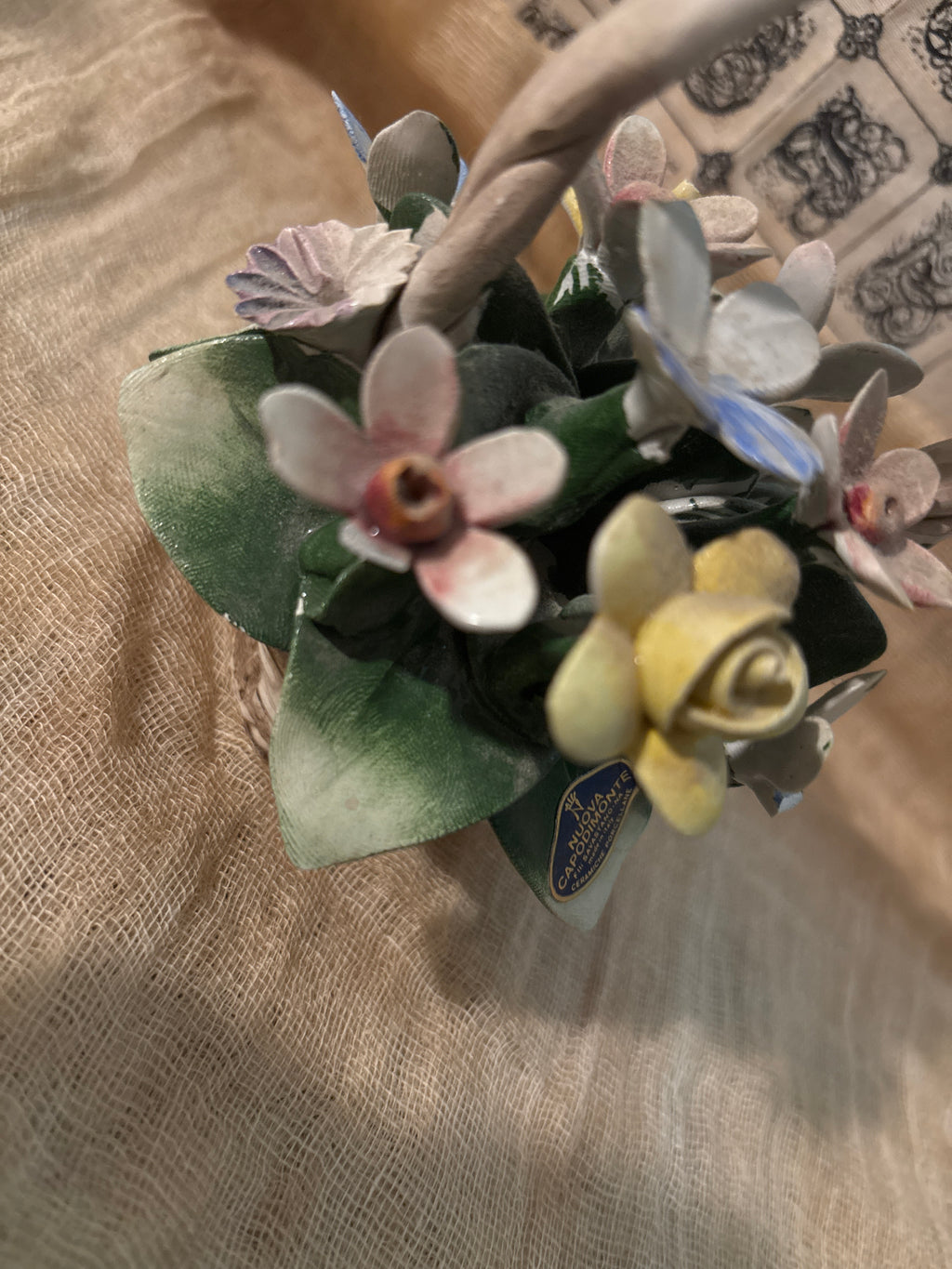 Capodimonte porcelain flower basket made in Italy, featuring a twisted handle topped with a blue bow.