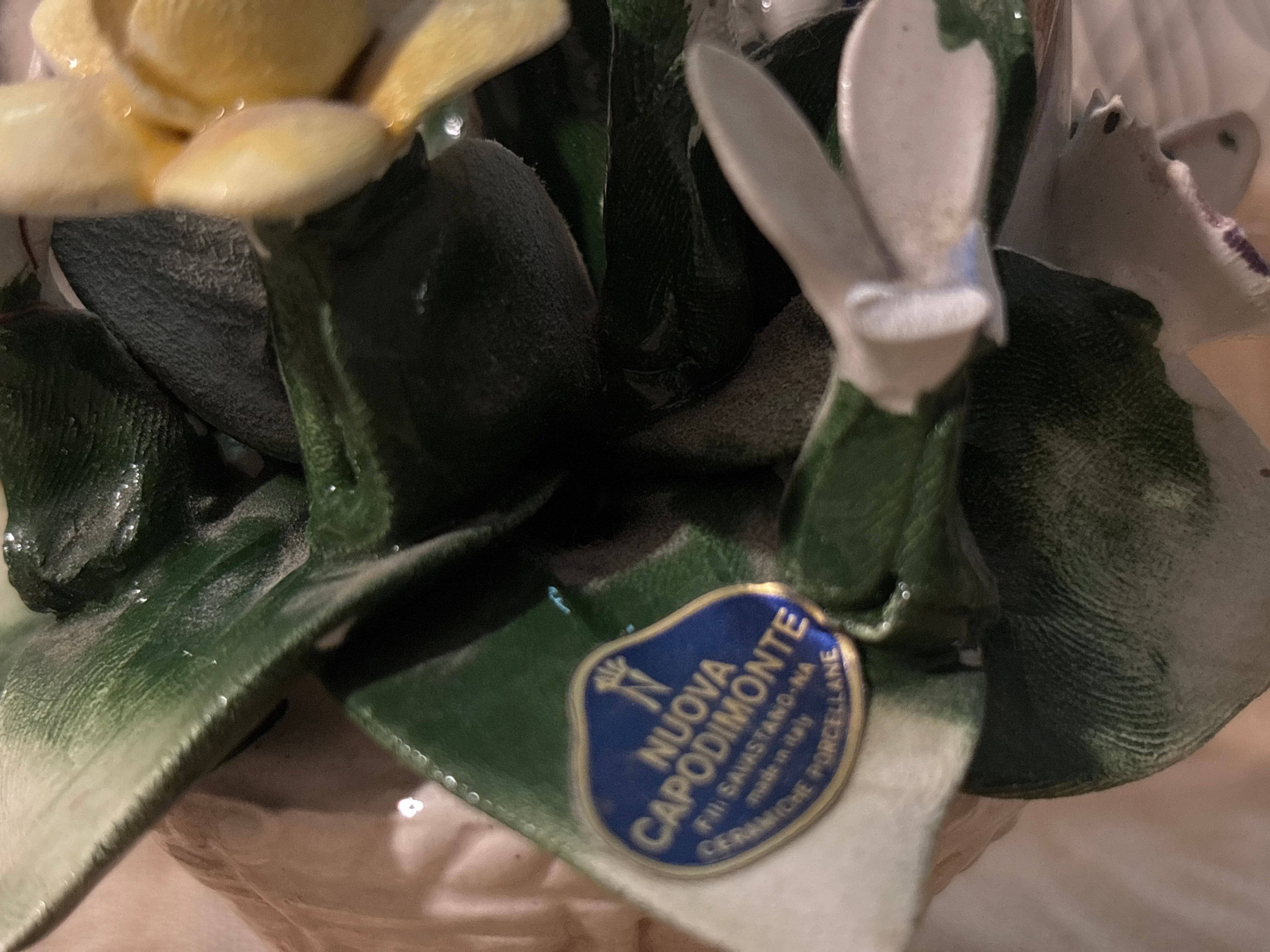 Capodimonte porcelain flower basket made in Italy, featuring a twisted handle topped with a blue bow.