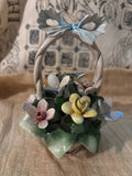 Capodimonte porcelain flower basket made in Italy, featuring a twisted handle topped with a blue bow.